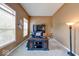 Cozy home office space with natural light, plush carpet, and a classic dark wood desk and shelving unit at 7212 Maple Bluff Pl, Indianapolis, IN 46236