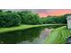 Scenic pond view reflecting a gorgeous sunset with trees surrounding the water's edge at 7212 Maple Bluff Pl, Indianapolis, IN 46236