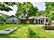 Expansive backyard featuring a stone house exterior, lush lawn, and a charming patio for outdoor enjoyment at 7242 Highburry Dr, Indianapolis, IN 46256
