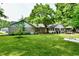 Spacious backyard with lush green lawn, stone house, and patio, creating an ideal outdoor living space at 7242 Highburry Dr, Indianapolis, IN 46256