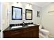 Bathroom with a dual sink vanity, dark countertops, and modern fixtures at 7242 Highburry Dr, Indianapolis, IN 46256