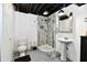 A full bathroom featuring gray and white tile, pedestal sink, and walk-in shower at 7242 Highburry Dr, Indianapolis, IN 46256