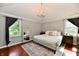 Cozy bedroom featuring a queen-sized bed, modern lighting, and beautiful wood floors at 7242 Highburry Dr, Indianapolis, IN 46256