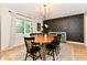 Dining room featuring an accent wall, modern chandelier, and a view of the backyard at 7242 Highburry Dr, Indianapolis, IN 46256