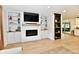 Living room with a fireplace, built-in shelving, modern lighting, and wood-look floors at 7242 Highburry Dr, Indianapolis, IN 46256