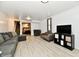 Finished basement living room with light floors, gray sectional sofa, and view into the bedroom and staircase at 7242 Highburry Dr, Indianapolis, IN 46256