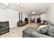 A finished living room area with gray sectional sofa, light wood-look floors, and a entertainment area at 7242 Highburry Dr, Indianapolis, IN 46256