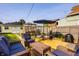 Backyard featuring a wooden deck with patio furniture, an umbrella, a garden, a greenhouse, and colorful landscaping at 743 Sanders St, Indianapolis, IN 46203