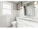 Bright bathroom features tiled walls, patterned floor, updated vanity with granite counters, and a window allowing for ample natural light at 743 Sanders St, Indianapolis, IN 46203