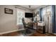 Bedroom featuring wood floors, a ceiling fan, a large window letting in natural light and an organized office area with multiple monitors at 743 Sanders St, Indianapolis, IN 46203
