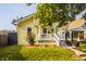 Charming yellow home with a welcoming front porch, green lawn, and lovely landscaping at 743 Sanders St, Indianapolis, IN 46203