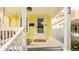 Close-up of the front porch with a swing, white railing, and entrance to a bright yellow house at 743 Sanders St, Indianapolis, IN 46203