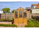 A backyard has a small greenhouse and raised garden beds surrounded by grass. A stone walkway leads up to the front door of the greenhouse at 743 Sanders St, Indianapolis, IN 46203