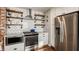 Modern kitchen with stainless steel appliances, open shelving, granite countertops, and tile backsplash at 743 Sanders St, Indianapolis, IN 46203