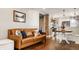 Comfortable living room featuring a leather sofa, hardwood floors, and a view into the stylish kitchen at 743 Sanders St, Indianapolis, IN 46203