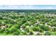 A picturesque aerial shot of a neighborhood blending mature trees with well-spaced homes under a partly cloudy sky at 7504 Troon Ct, Indianapolis, IN 46237