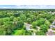 Aerial view capturing a quiet neighborhood with green trees surrounding well-maintained homes on spacious lots under a blue sky at 7504 Troon Ct, Indianapolis, IN 46237