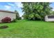 Green grass with large trees and a shed in the distance at 7504 Troon Ct, Indianapolis, IN 46237
