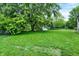 Backyard with a shed and large shady trees and green grass at 7504 Troon Ct, Indianapolis, IN 46237