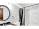 Bathroom with round mirror, dark granite, and shower with gray curtain at 7504 Troon Ct, Indianapolis, IN 46237