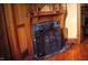 A close-up of a fireplace, with an ornate screen, in a room with yellow walls and hardwood floors at 783 Woodruff Place Middle Dr, Indianapolis, IN 46201