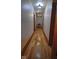 A long hallway featuring hardwood floors, white walls, and striking lighting fixtures at 783 Woodruff Place Middle Dr, Indianapolis, IN 46201