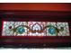 A decorative stained glass window with floral design and colorful accents above a window sill at 783 Woodruff Place Middle Dr, Indianapolis, IN 46201