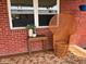 Charming wicker chair sits outside, enhancing curb appeal with a vintage touch and fresh flowers at 8990 N 850 W, Fairland, IN 46126