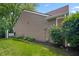 Side view of home with vinyl siding, green grass, garden bed and mature landscaping at 9700 River Oak E Ln, Fishers, IN 46038