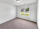 Bright bedroom featuring plush carpeting and a window offering neighborhood views at 10112 James Run Dr, Indianapolis, IN 46239