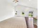Bright living room featuring vaulted ceilings, neutral carpet, and a sliding glass door to the backyard at 10112 James Run Dr, Indianapolis, IN 46239