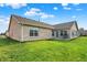 Expansive backyard with lush green grass, patio seating, and a well-maintained brick home at 1056 Hilltop Commons Blvd, Whiteland, IN 46184