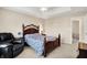 Cozy main bedroom featuring a classic wooden bed frame, comfortable recliner, and soft natural light at 1056 Hilltop Commons Blvd, Whiteland, IN 46184