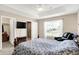 Bright main bedroom with a large window, comfortable armchair, and modern entertainment setup at 1056 Hilltop Commons Blvd, Whiteland, IN 46184