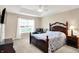 Comfortable main bedroom with a tray ceiling, plush armchair, and ample natural light from the window at 1056 Hilltop Commons Blvd, Whiteland, IN 46184