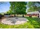 Landscaped backyard featuring a stone fire pit, picnic table, and lush green lawn, perfect for outdoor relaxation at 106 N Jamalee Way, Pendleton, IN 46064