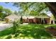 Charming red brick home featuring a well-manicured front yard with mature trees and a cozy front patio at 106 N Jamalee Way, Pendleton, IN 46064