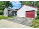 Backyard featuring a grey home, a white garage with a red door, and a driveway at 11 14Th St, Franklin, IN 46131