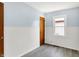 Bedroom featuring light blue walls, wood-look floors, a window, and white wainscoting at 11 14Th St, Franklin, IN 46131