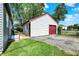 Image of the garage with a red door and a grassy yard at 11 14Th St, Franklin, IN 46131