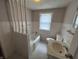 A cozy bathroom featuring tiled walls, a window with curtain, and a combined tub and shower at 114 S Green St, Brownsburg, IN 46112