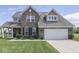 Charming two-story brick home featuring a well-manicured lawn and attached two car garage at 1215 W Curry Rd, Greenwood, IN 46143