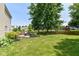 Large, grassy backyard with a patio area and mature trees providing shade at 12343 Slate Dr, Fishers, IN 46037