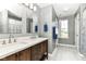 Modern bathroom features a double vanity, wood-look tile flooring, and soft gray walls, perfect for your home at 12343 Slate Dr, Fishers, IN 46037