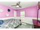 Cozy bedroom with ceiling fan, soft carpet, wainscotting, and pink walls enhanced by decorative wall art at 12343 Slate Dr, Fishers, IN 46037
