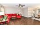 Cozy living room features a red sectional sofa, wood floors, and a ceiling fan, great for relaxing and entertaining at 12343 Slate Dr, Fishers, IN 46037