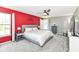 Comfortable main bedroom with a red accent wall, ceiling fan, and windows allowing ample natural light at 12343 Slate Dr, Fishers, IN 46037