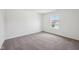 A carpeted bedroom featuring a window with a view of a house at 1304 Vera Blvd, Danville, IN 46122