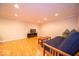 Finished basement area with hardwood floors, recessed lighting, and a comfortable futon couch at 13910 Brightwater Dr, Fishers, IN 46038