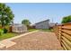 Private backyard with a greenhouse, gravel area, and wooden fence, perfect for gardening and outdoor activities at 1622 Cornell Ave, Indianapolis, IN 46202